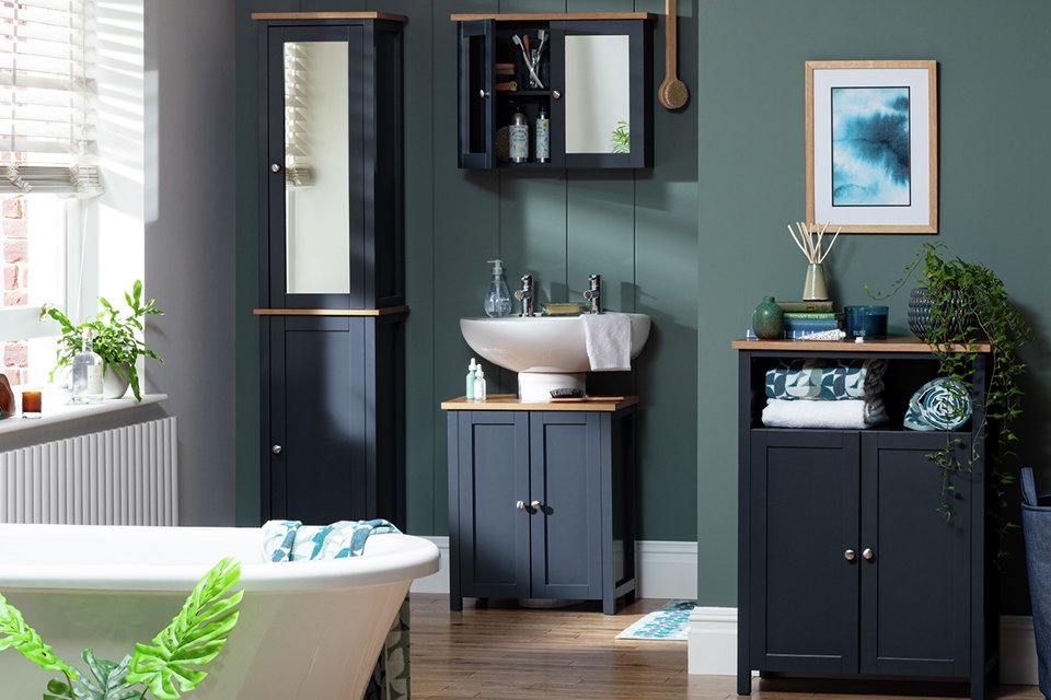 A clean bathroom with dark blue storage units and a bathtub.